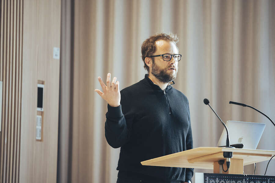 A man gesticulating at the lectern.