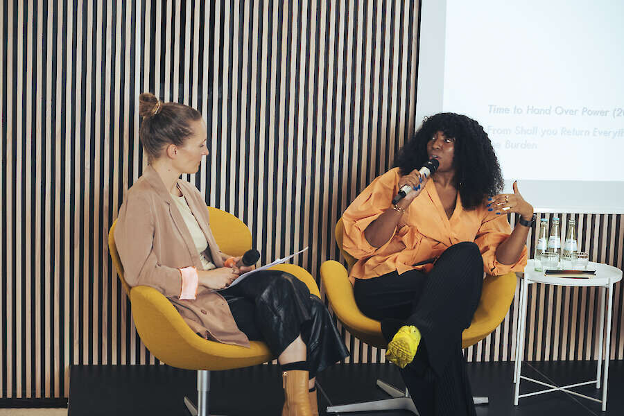 Lucia Halder and Lebohang Kganye sit on two chairs with a microphone for an artist talk.