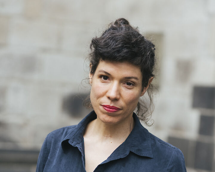 Pauline Hafsia M'barek mit dunklem hochgestecktem Haar. Sie trägt eine blaue Bluse.  © buerofuerkunstdokumentation