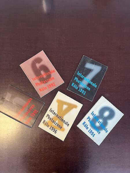 The issues of Photoszene Festival 5-10 are lying on a dark table.